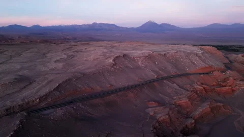 Panoramic drone shot over a desert road cutting across eroded canyon ridges at Stock Footage 333206861