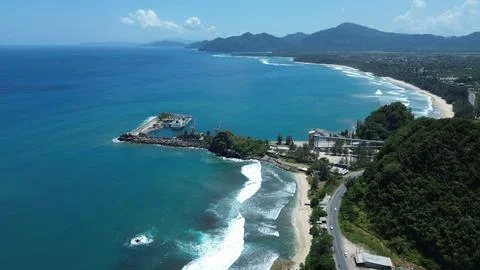 Panoramic drone shot of a seaside harbor, sandy beach, and scenic coastal road 스톡 사진