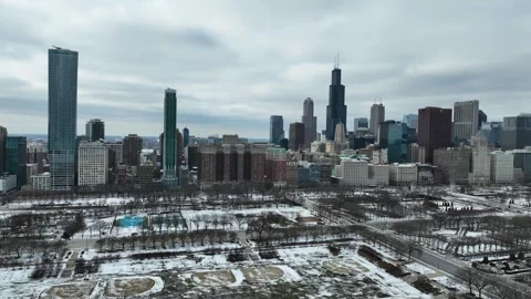 Panoramic drone shot of the snowy parks of Chicago and the gloomy Loop cityscape Stock Footage 345542840