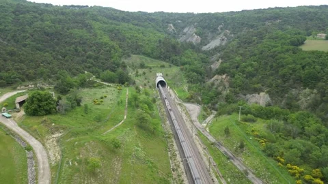 Panoramic drone view of a high-speed passenger train leaving the tunnel Stock Footage 243838620