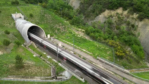 Panoramic drone view of a high-speed passenger train entering a tunnel Stock Footage 243838704