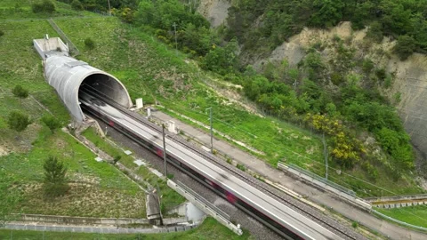 Panoramic drone view of a high-speed passenger train leaving the tunnel Stock Footage 243838892