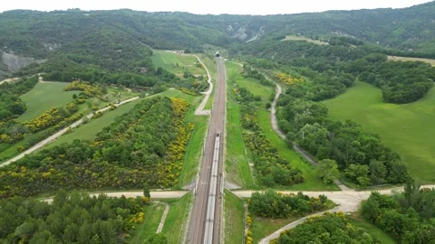 Panoramic drone view of a high-speed passenger train entering a tunnel Stock Footage 243839146