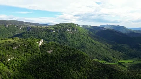 Panoramic drone view of tree-covered hillsides of the heights of the Vercors Stock Footage 242724179
