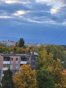 Panoramic elevated view of city rooftops and autumn parkland Stock Photos