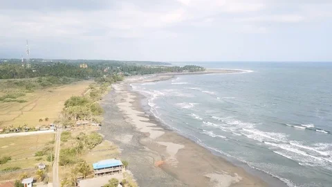 Panoramic flight left revealing surfing bay with large waves in the tropics Stock Footage 119701580