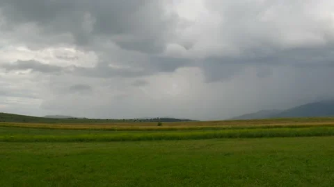 Panoramic footage of dramatic stormclouds over green meadow at sunset Stock Footage 135699219