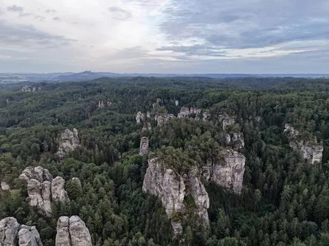 Panoramic forested sandstone cliffs rising above green ridgelines under clo.. Stock-Fotos