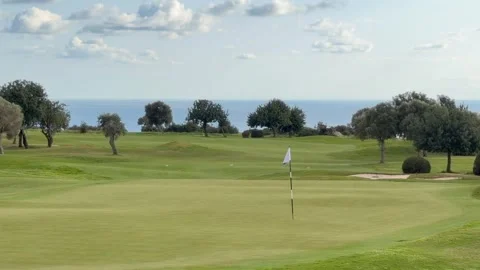 Panoramic golf course with lush green fairway stretches toward distant sea Stock Footage 334319901
