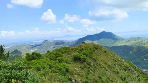 Panoramic green mountain ranges under a bright blue sky Vídeo Stock 342259200