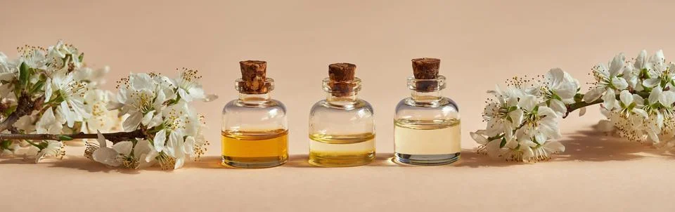Panoramic header with three bottles of essential oil on peach orange backgrou Foto stock