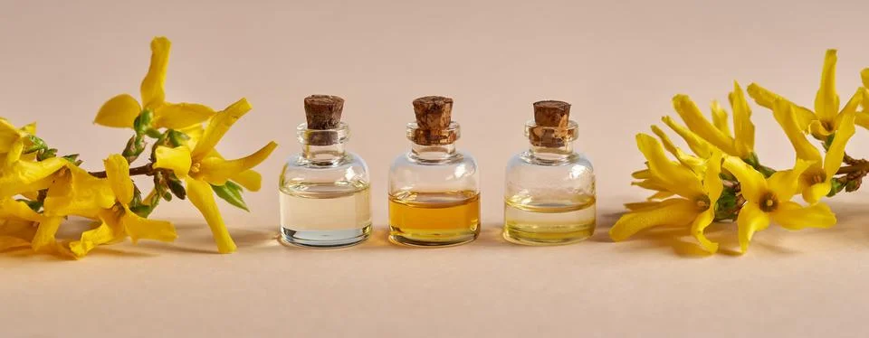 Panoramic header with three bottles of essential oil and spring flowers - for Stock Photos