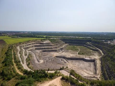 Panoramic high angle drone view of deep open pit stone quarry and mining site Stock Photos