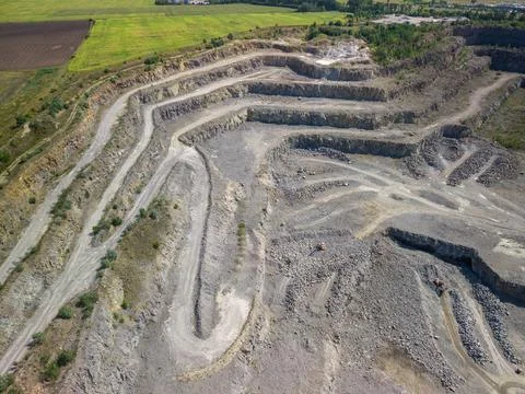 Panoramic high angle drone view of terraced open pit granite stone quarry Fotos Stock
