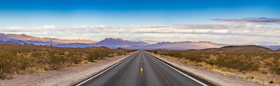 Panoramic image of a lonely, seemingly endless road in the desert 写真素材