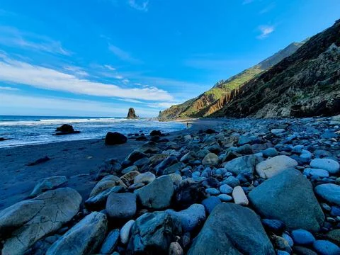 Panoramic of an impressive remote beach with mountains and sharp rocks Stock Photos
