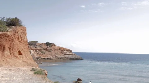 Panoramic landscape of Ibiza beach with cloudy blue sky, orange rocks and blue Stock-Footage 110915270