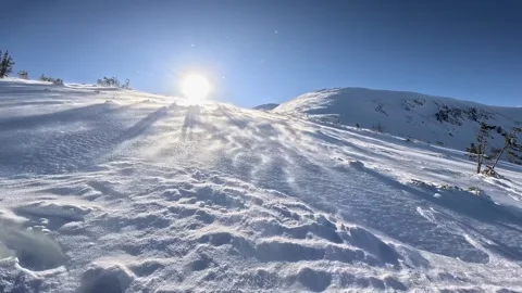 Panoramic Low Angle View of Extreme Wind Blowing Snow on a Sunny Mountain Stock Footage 321751207