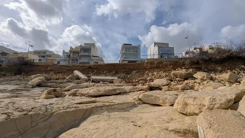 Panoramic low angle view of golden eroded limestone shoreline in Malta with w Stock Photos