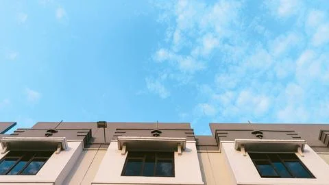 Panoramic low-angle view of residential beige facade with multiple window f.. Stock Photos