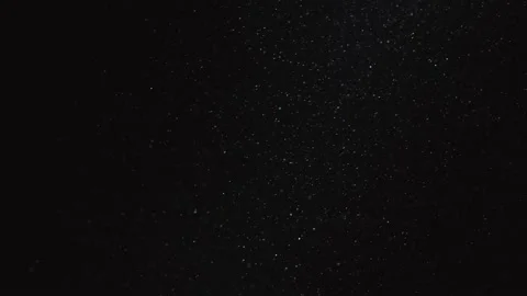 Panoramic motion of fine dust on a black background. Shiny dust particles float Stock Footage 139554613