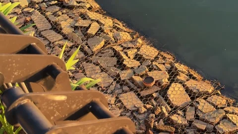 Panoramic motion shot of Gabion Riprap Riverbank at Sunset Vídeo Stock 343697239