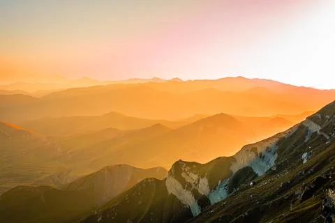 Panoramic mountain landscape in the rays of the setting sun. Stock Photos