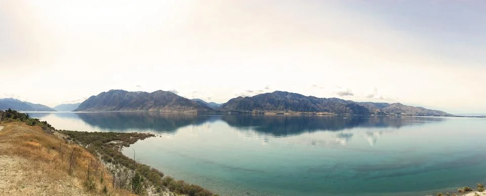 Panoramic mountain reflection on a peaceful alpine lake - Serene landscape .. 写真素材