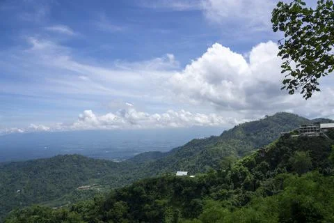 Panoramic Mountain View Over Lush Hills With Clouds and Distant Cityscape Stock Photos