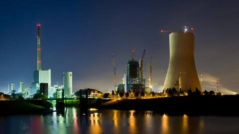 Panoramic night shot of an old coal power station and a new one under constru Stock Photos