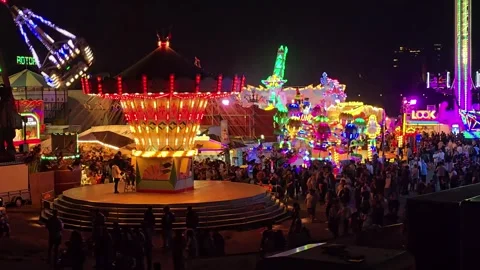Panoramic Night View of a Carnival with Carousel and Crowd Stock Footage 341628760