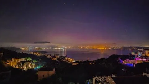 Panoramic night view of glowing resort town lights around calm Mediterranea.. Stock Photos