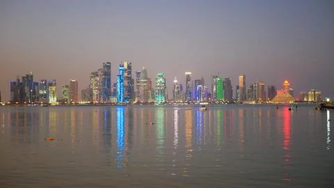 Panoramic night view of the illuminated Doha skyline along the Corniche, with co Fotos de archivo