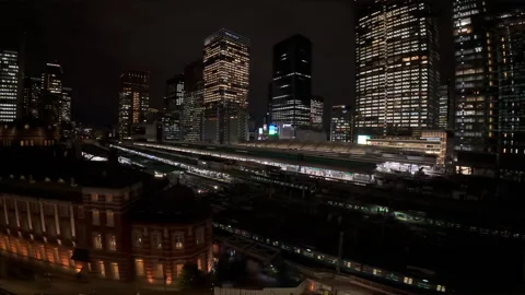 Panoramic night view of Tokyo Station with trains arriving and departing Stock Footage 329858259
