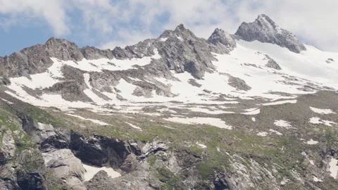 Panoramic pan-shot of Mountains covered partly with snow Stock Footage 283563591