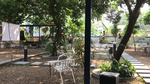 Panoramic Pan Shot Of Tranquil Outdoor Garden Coffee Shop Area 스톡 동영상 340960958