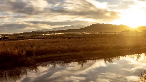 Panoramic panning time lapse of a golden sunset reflecting off the water Stock Footage 106736491