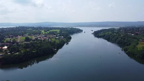 Panoramic River View with Lush Greenery and Distant Hilly Landscape Under a Stock Footage 314473696