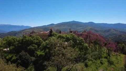 Panoramic rotating view of a hilltop monastery village in spring forest Stock Footage 337048640