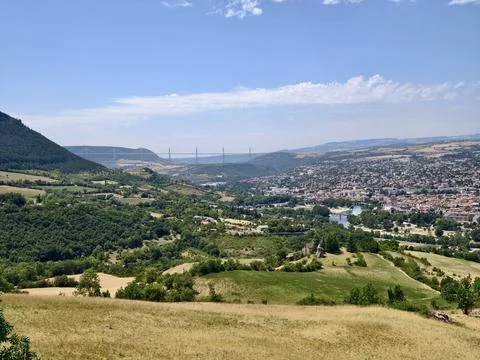 Panoramic rural valley with distant cable-stayed bridge above river, rollin.. Stock Photos