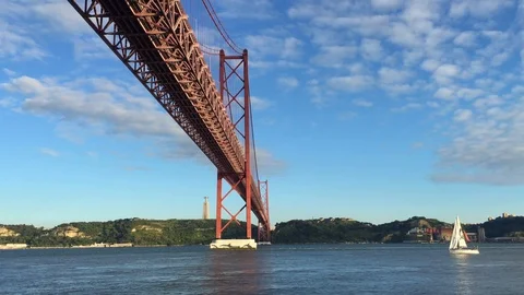 Panoramic shot. 25th april Bridge in Lisbon with a boat sailing on the river Stock Footage 91748150