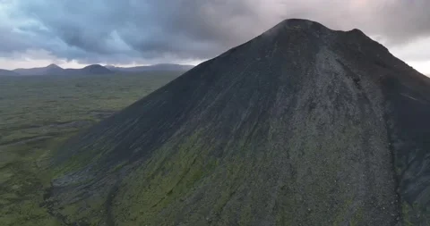 A panoramic shot across a field of rocks and moss-covered mountains Stock Footage 238817867