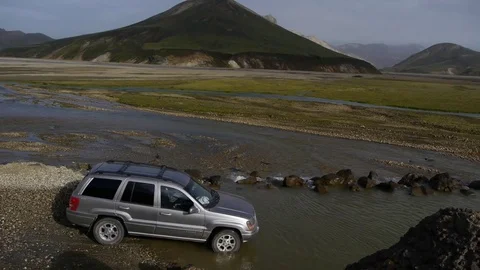 Panoramic shot of a car crossing a ford in Landmannalaugar, in Iceland Stock Footage 71282001
