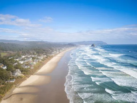 Panoramic shot of the ocean. Light waves crash on the yellow sandy shore. Blu Stock Photos
