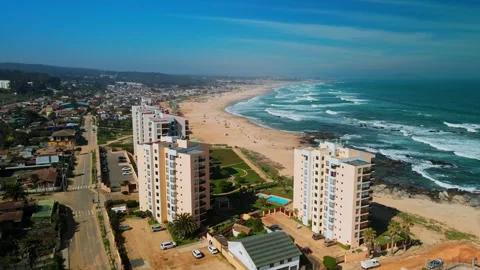 Panoramic shot over beachfront apartment complex with pool revealing long 動画素材 332710626