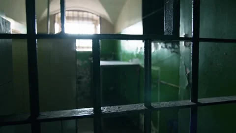 Panoramic shot of the prison cell with bars in the foreground Stock Footage 303552702