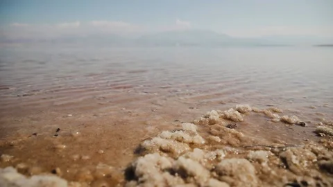 Panoramic shot from steadicam of Dead Sea coastline with salt minerals in it Stock Footage 181645971