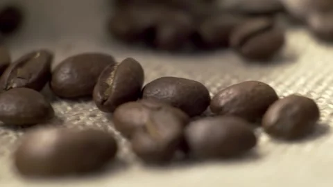 Panoramic slow-motion macro shot of scattered roasted coffee beans Stock Footage 159582004