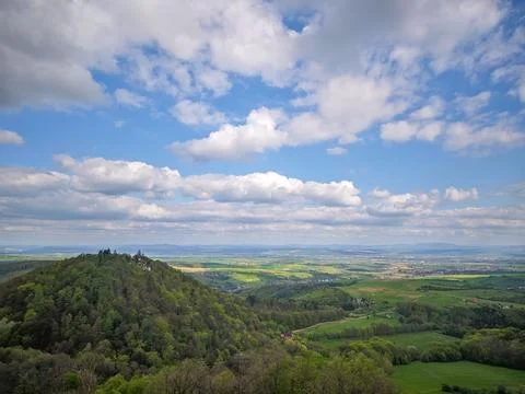 Panoramic spring view over the Moravian countryside with forested hill Stock Photos