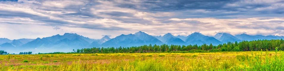 Panoramic summer landscape of mountain range with peaks, valley with green gr Stock Photos